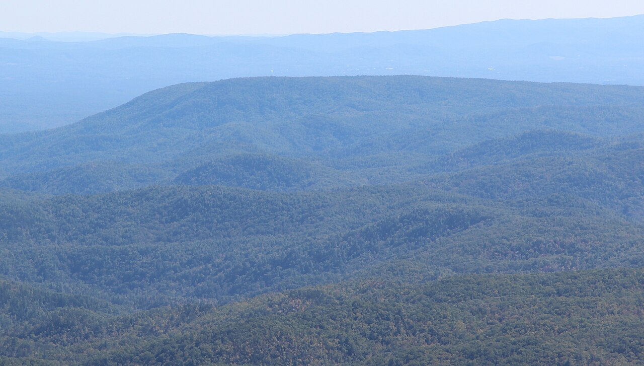 A wide view of the forested Brown Mountain ridge in North Carolina under a blue sky